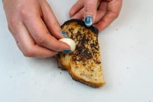 Rubbin the bread with garlic
