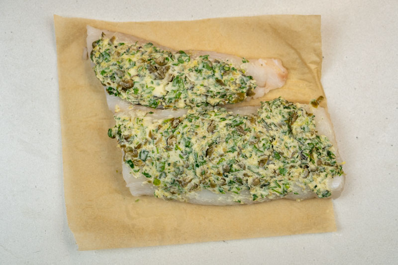 Spreading the herb butter on the fish