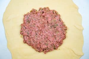 Adding the meat filling to the dough